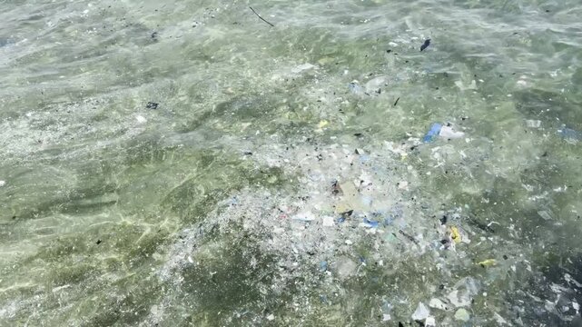 Plastic waste and microplastic debris polluting ocean water surface, environmental pollution concept