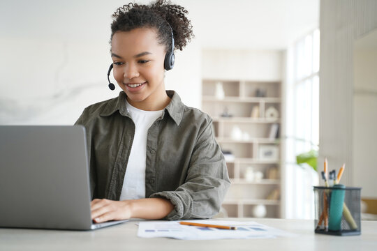 Black woman wearing headset working on laptop in customer support call