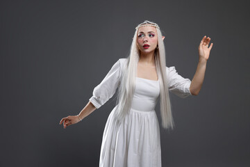 Naklejka premium Beautiful girl dressed as elf on grey background