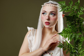 Naklejka premium Beautiful elf girl with floral decor on dark olive background, space for text