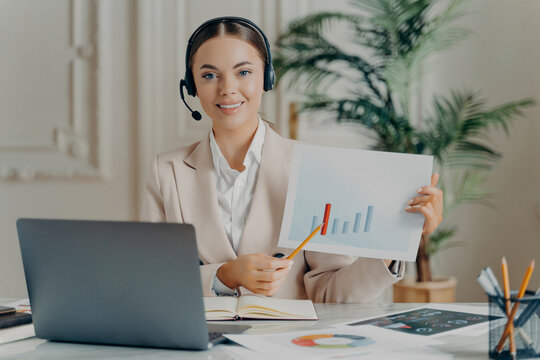 Customer support woman wearing headset presenting sales chart on video call