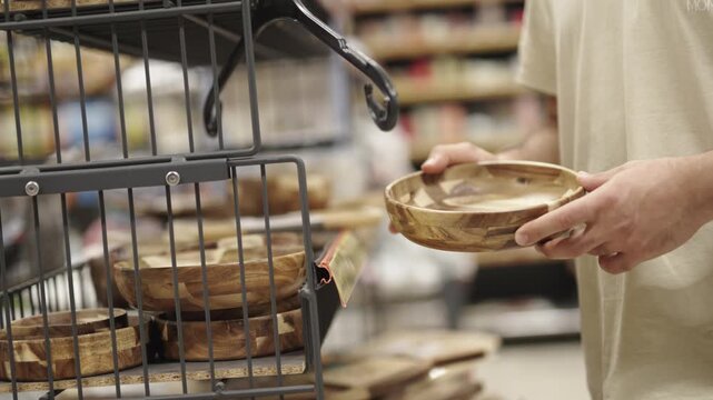 Man looking at ceramic plates in a supermarket department