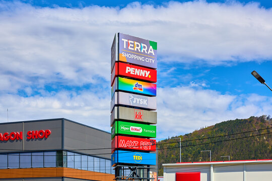 Shopping center signs against clear sky near green hills. April 23, 2026, Piatra Neamt, Romania