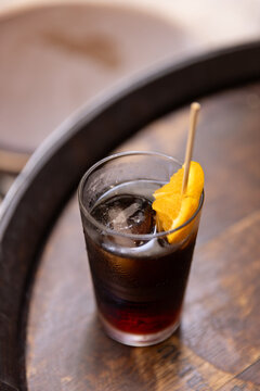 top down angle of glass of vermouth on wood barrel table in barcelona spain