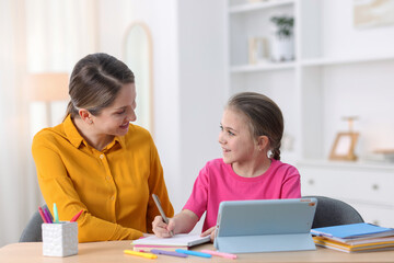 Fototapeta premium Mother and daughter using tablet for studying at home