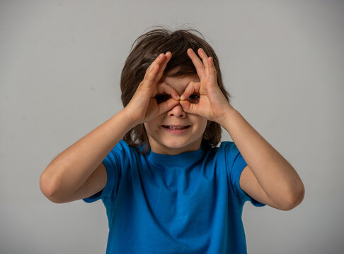 Boy making binocular gesture.