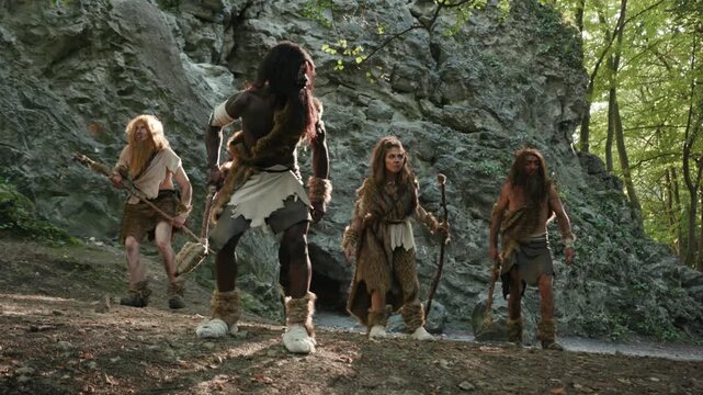 A prehistoric scene with cavemen engaged in activities, depicting ancient human life