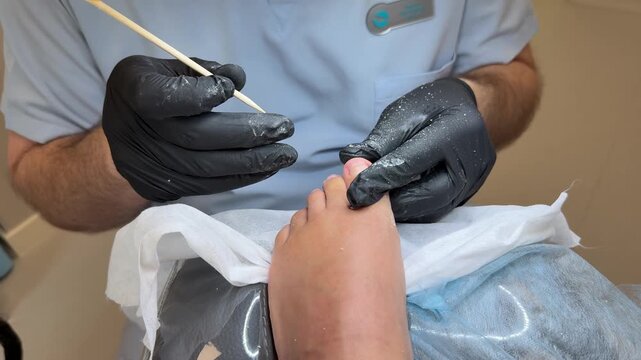 Professional pedicure on foot with nail tool, close up salon procedure