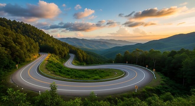 Winding road through lush green hills under a colorful cloudy sky at sunset