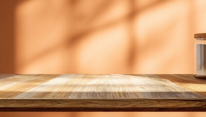 Fototapeta premium A sunlit wooden surface and wall create a warm, inviting minimalist scene with a glass jar.
