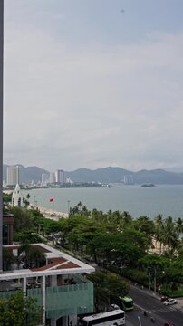 Nha Trang Vietnam 25 04 2026 Nha Trang Bay Skyline With Palm Trees, Quiet Morning Traffic, Hotel Buses And Coastal Hills, Overcast Sky, Seaside Promenade And Park, Tour Buses Arriving, Vendors