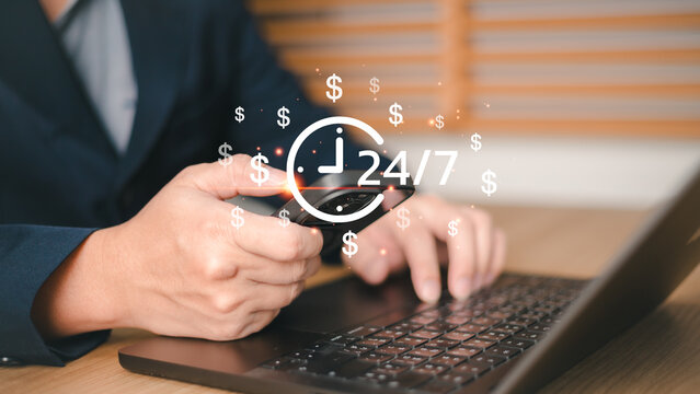 Businessman using smartphone and laptop with 24 hours a day and 7 days a week service icon,. Concept of passive income, online banking, financial success time management for global business 24 hours