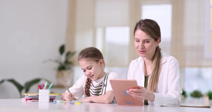 Mother and daughter using tablet for studying at home