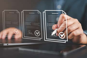 Businessman reviewing and signing digital contracts on laptop, representing document approval,...