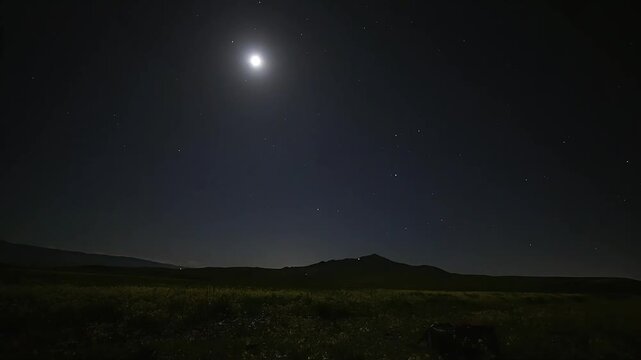 High resolution time-lapse showing the moon and stars moving together across the dark night sky over a quiet field in China Native China Lens