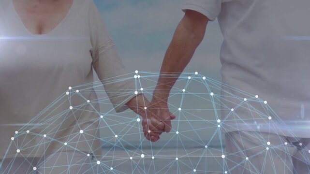 Senior woman and man holding hands, camera pulling back, healthcare mesh dome connecting them