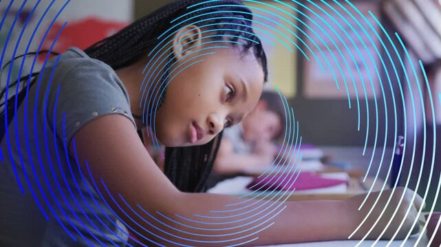 Female student after teacher prompt leaning over notebook, writing classwork, blue circles sweeping