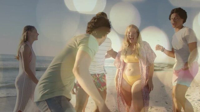 Six adults walking on beach, camera cueing, closing crouching raising arms, bokeh framing travel ad