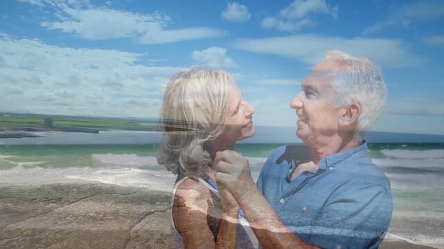 Senior couple holding hands touching and swaying with ocean overlay showing love for marketing
