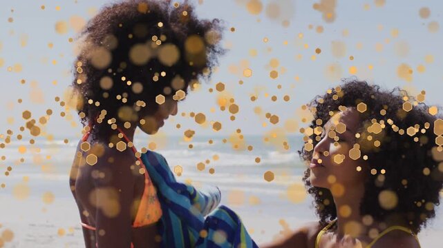 Mother reaching, wrapping towel around child for warmth on beach in health, gold overlay drifting