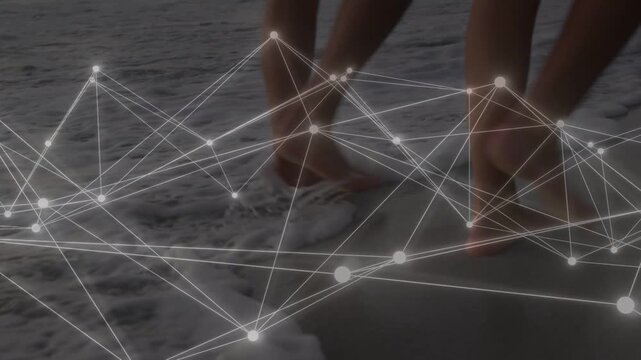 Two adults strolling shoreline, feet stepping wet sand and syncing animated tech network with steps