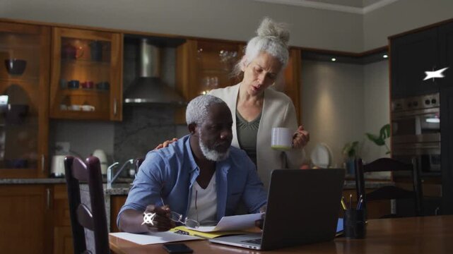 Man checking bills at laptop while woman leaning, hand resting, causing cyan streaks for finance