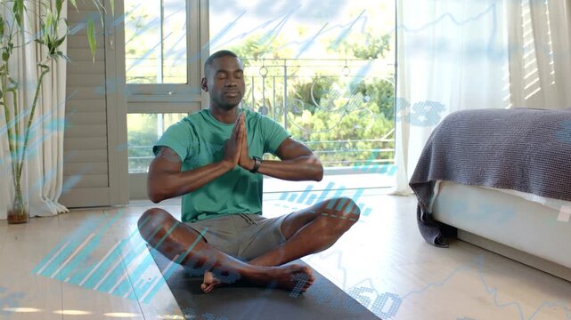 Man initiating breath, raising palms to prayer, settling into mudra on black mat for wellness