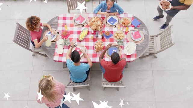 Group preparing meal on patio, guests bringing salad and rolls, passing dishes, stars overlaying
