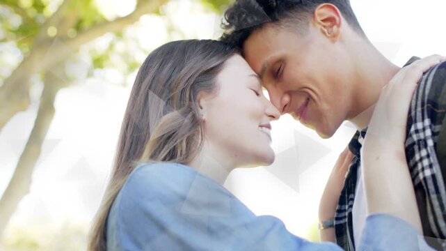 Woman tucking hair man leaning heads amid trees, soft smiles showing connection causing bokeh ads