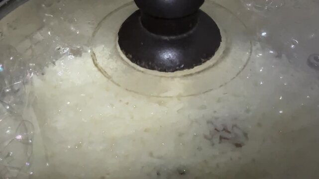 White Rice Cooking Inside an Electric Rice Cooker with Glass Lid