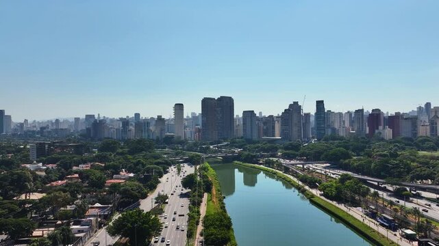 S&atilde;o Paulo skyline with Marginal Pinheiros and river, showing urban landscape, highways, bridges and modern buildings under clear blue sky.