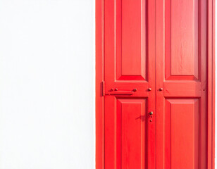 Obraz premium Bright red double doors with metal hardware against a stark white wall with a subtle texture