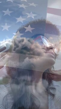 Vertical video: Teen looking up and adjusting hat and shades, flag overlay remaining for marketing
