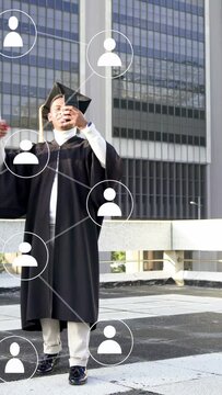 Vertical video: Graduate angling phone with diploma on rooftop, sharing edu network icons expanding