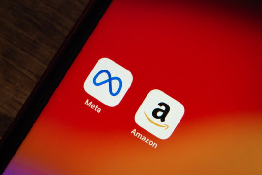 Mexico City, MEXICO - Apr 27 2026 : Close-up of an iPhone home screen showing the Meta and Amazon icons on a vivid red-to-orange gradient background.