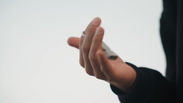 Closeup of hand confidently tossing key with speed. Hand energetically spins and tosses key fob with assurance. Closeup captures Caucasian hand confidently and rapidly flipping and tossing key fob