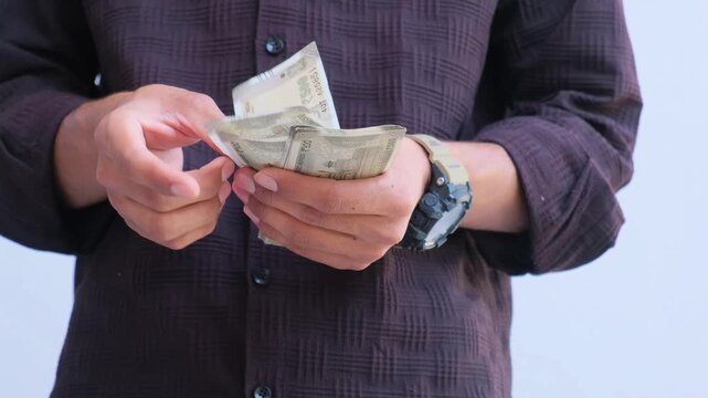 man counting a stack of 500 Rupee Indian currency notes