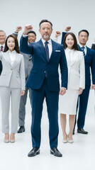Obraz premium United in Vision: A determined group of business professionals stands together, their raised fists symbolizing unity, strength, and a shared purpose.