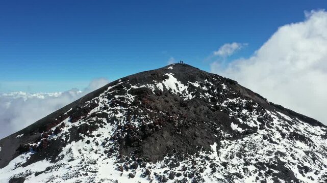 Hikers are standing on the summit of the Tungurahua volcano in Ecuador, South America