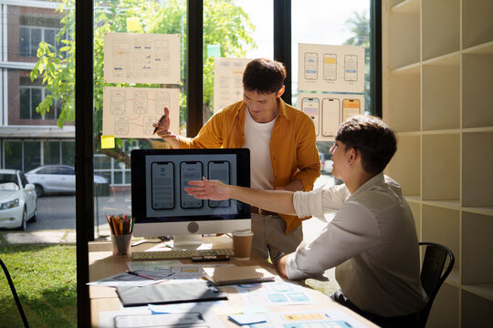 UX UI designers presenting interface concepts, sharing feedback and refining digital product screens during a productive meeting