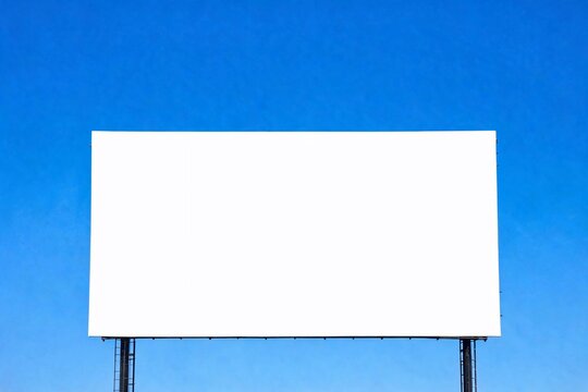 White billboard stands tall against clear blue sky.
