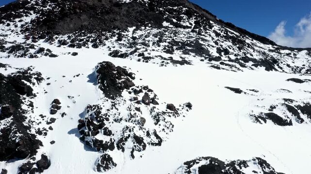 Beautiful close up of an in snow covered patch of rocks on the top of a mountain in the Andes