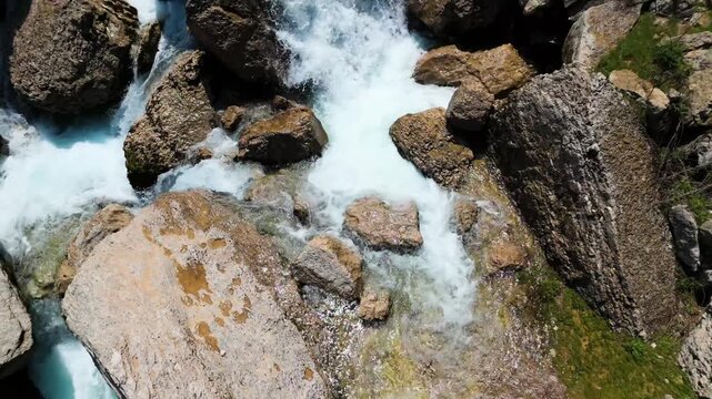 Drone footage of water flowing between tall rock formations in Faraya with natural greenery and fresh spring view