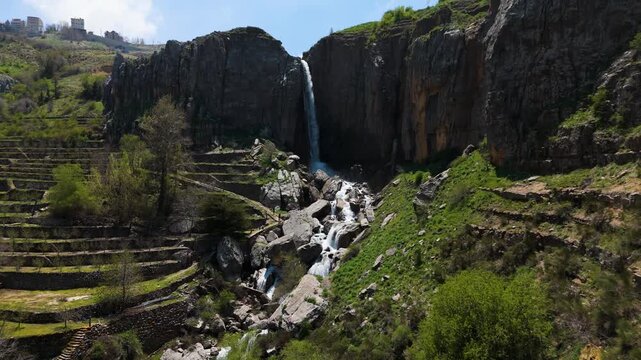 Drone shot capturing a waterfall in the mountains of Faraya Lebanon with fresh nature and rocky terrain