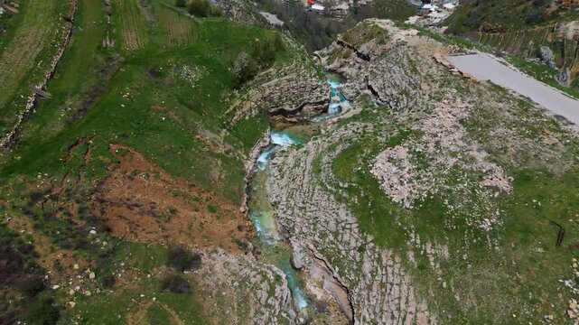 Aerial drone shot of a beautiful waterfall in Faraya Lebanon with rocky cliffs and green nature landscape