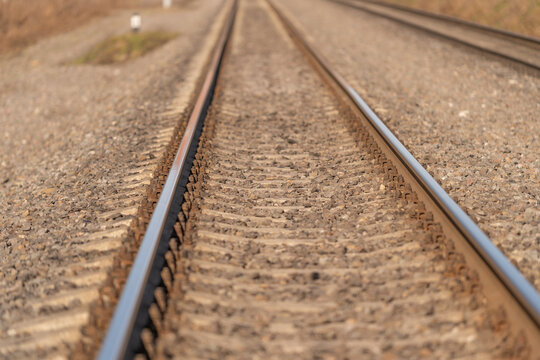 Tracks fade away. Rails stretch into silent fog. Railway disappears into tranquil morning mist. Endless train paths vanish into calm and peaceful vapors of morning
