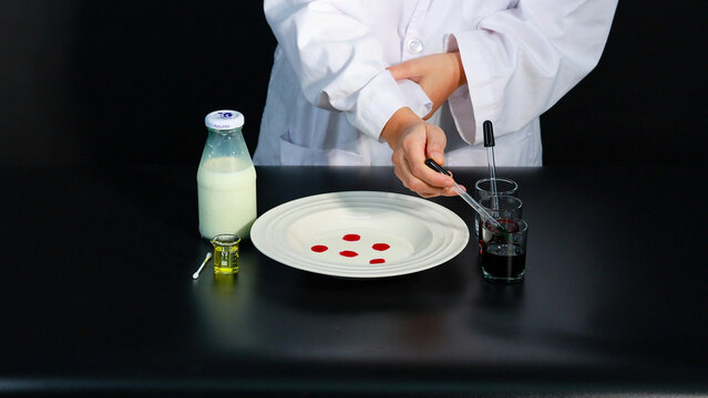 Person in Lab Coat Preparing Color Explosion Milk Science Experiment