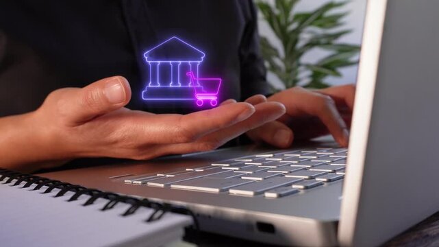 Banking system applied to commerce. Close-up of a businesswoman's hands working on her laptop while holding a virtual bank and shopping cart icon