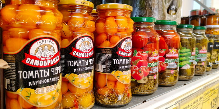 Russia, Samara. February 11, 2025. Canned glass jars of marinated cherry tomatoes. Text in Russian: self-assembled tablecloth, tomatoes, cherry, marinated, honey, assorted