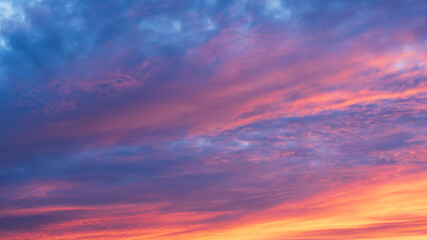 Fototapeta premium Vibrant colorful sunset sky with dramatic clouds and soft gradient tones